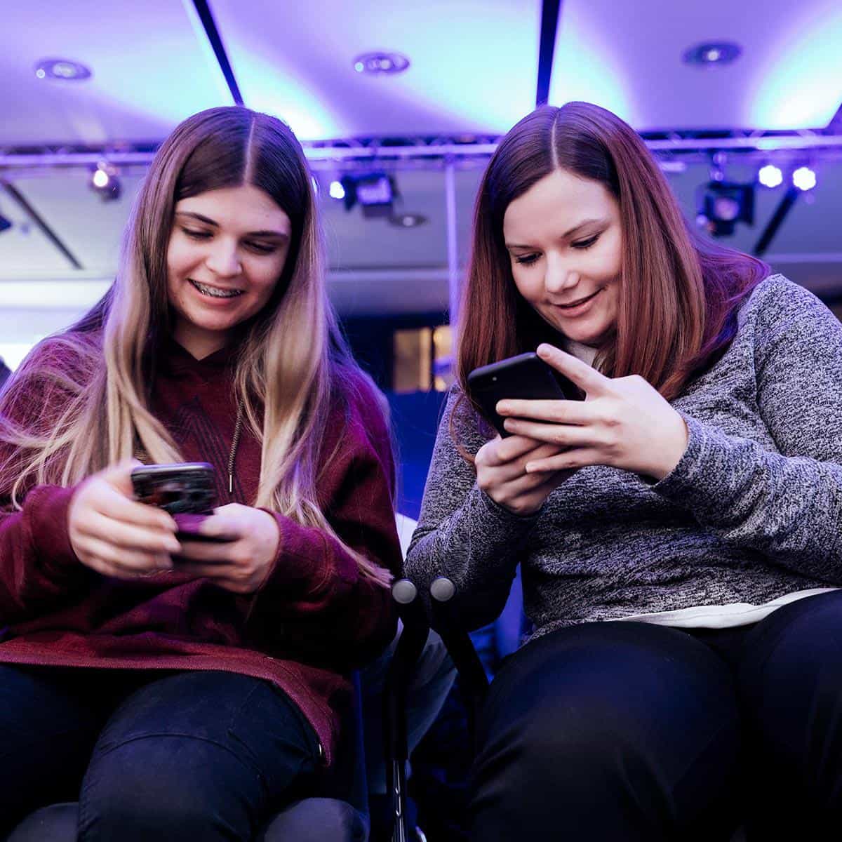 Zwei junge Frauen arbeiten im Smartphone