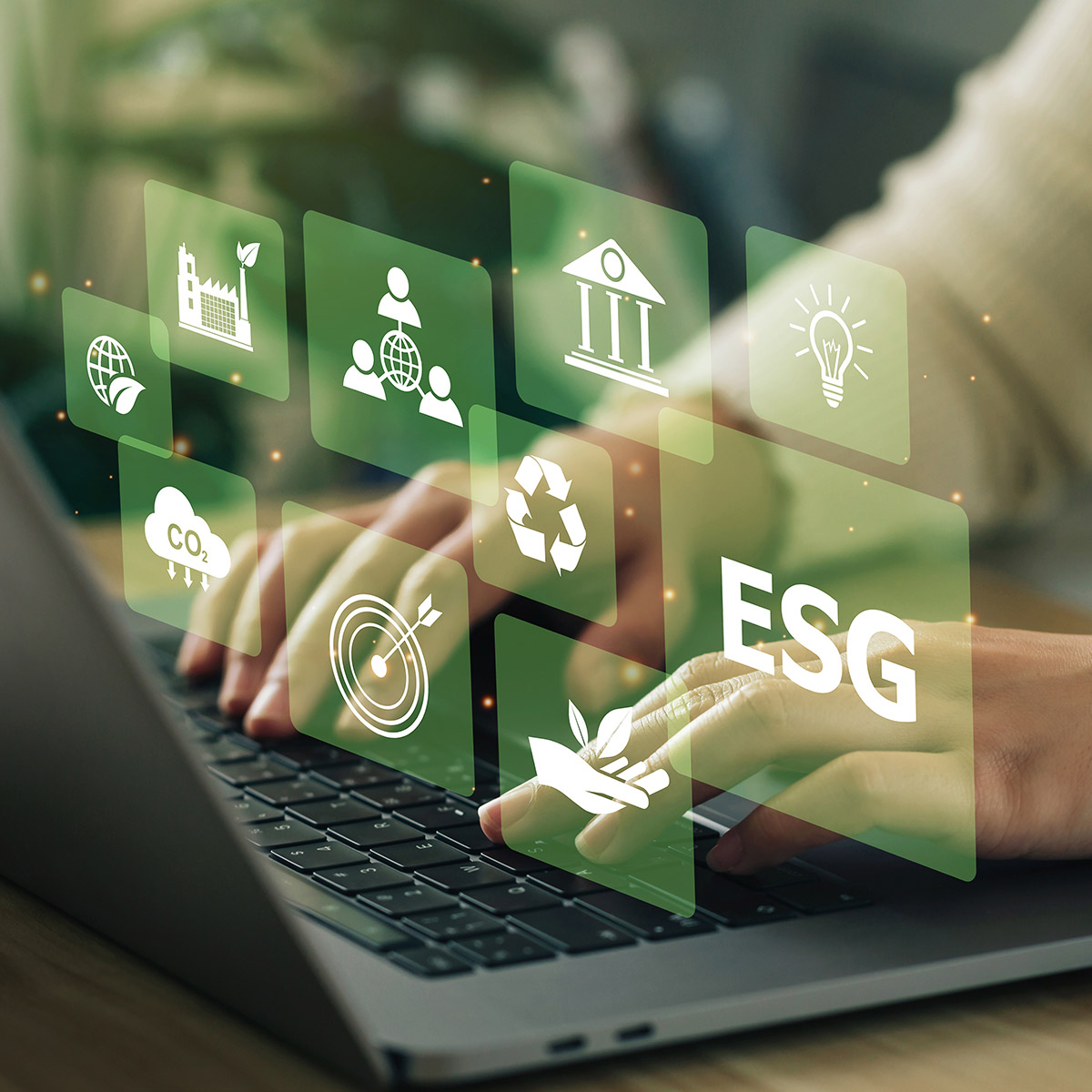 Hände tippen auf einem Laptop; darüber ESG-Schriftzug und Symbole für Umwelt und Nachhaltigkeit, ki-generiert.