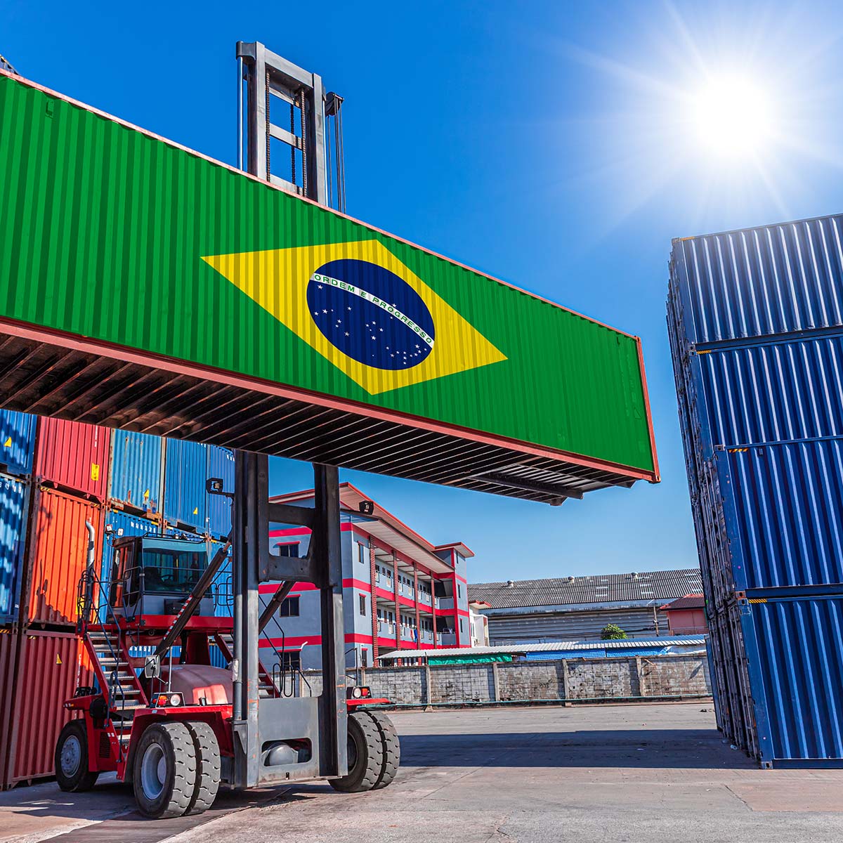 Container mit brasilianischer Flagge und ‚Ordem e Progresso‘ wird auf einem Terminal per Stapler bewegt.