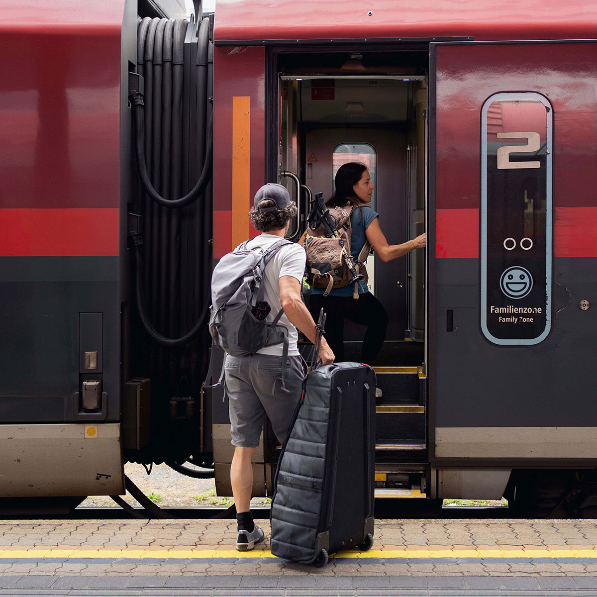 Zwei Reisende besteigen einen ÖBB-Railjet am Bahnhof Innsbruclk